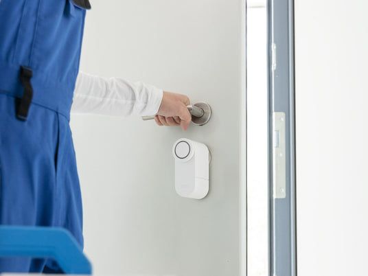 Handwerker öffnet die Tür mit dem ABUS LOXERIS One per Smartphone