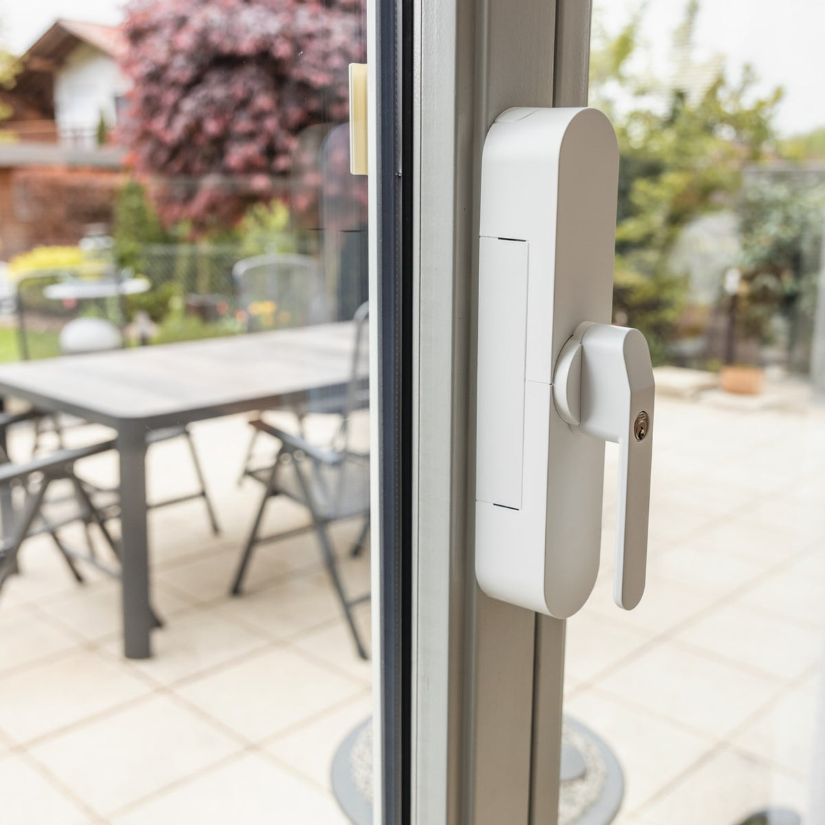 ABUS WINTECTO One am Griff der Terrassentür, Blick auf die Terrasse